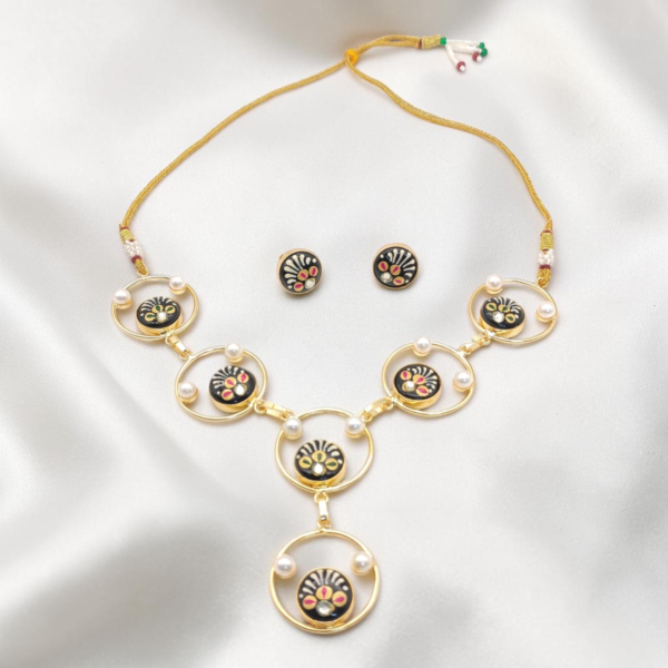 Black Hand-Painted Monalisa Stone Necklace Set in gold-tone brass with Tanjore-inspired motifs, Monalisa stones, pearl accents and matching stud earrings.
