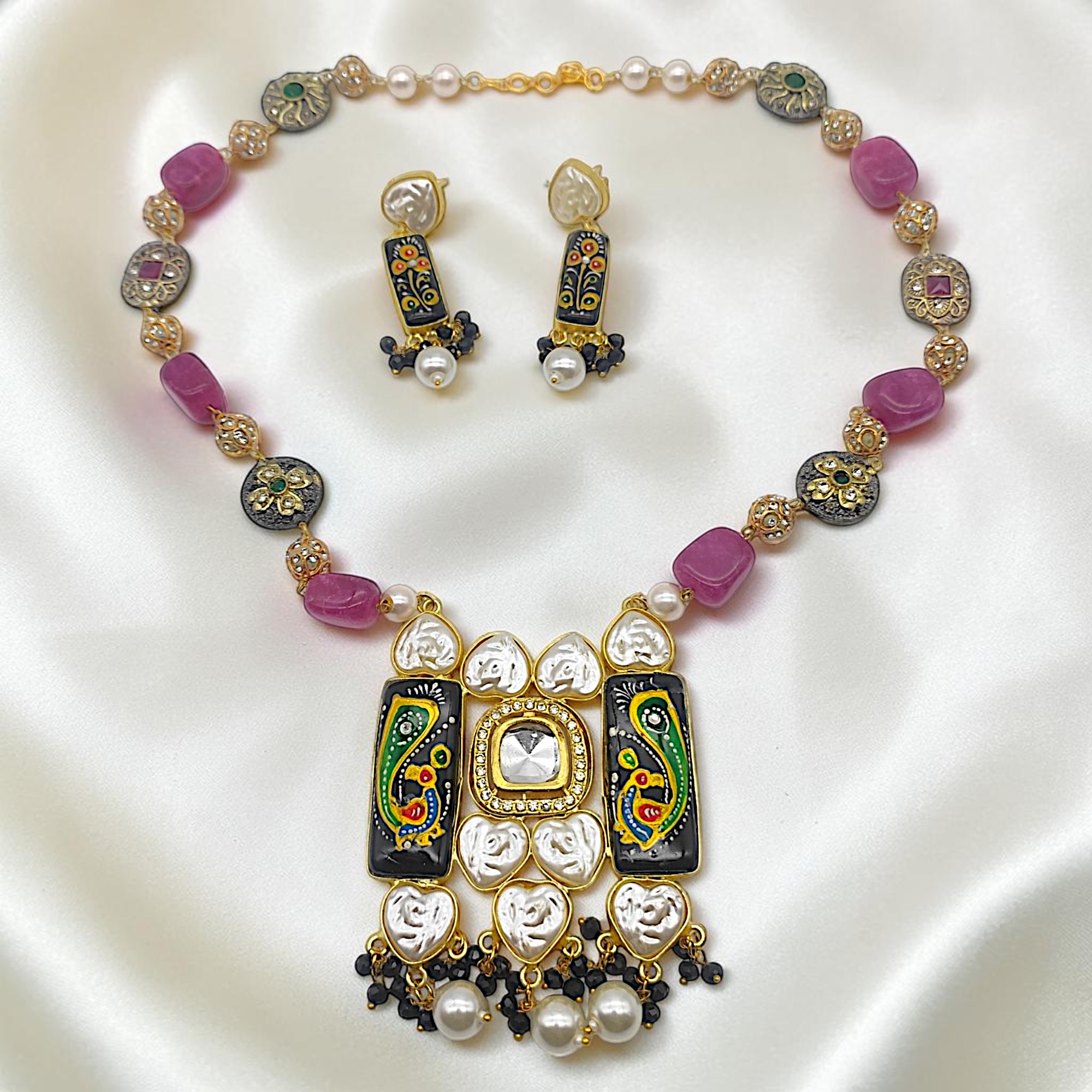 Black hand-painted Monalisa stone Tanjore necklace set with stylised peacock artwork, natural bead stones, kundan-style detailing, heart-shaped pearl accents, artificial pearl drops and matching drop earrings.