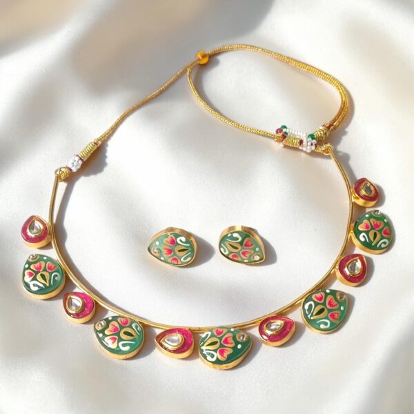 Emerald Green Hand-Painted Monalisa Stone Brass Hasli Set featuring Tanjore-inspired floral artwork on hand-painted Monalisa stones, red Monalisa stone accents, kundan-style detailing and matching earrings.