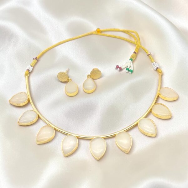 Milky White Monalisa Stone Brass Hasli Set with teardrop-shaped Monalisa stones, gold-plated brass hasli, matching earrings and adjustable thread closure.