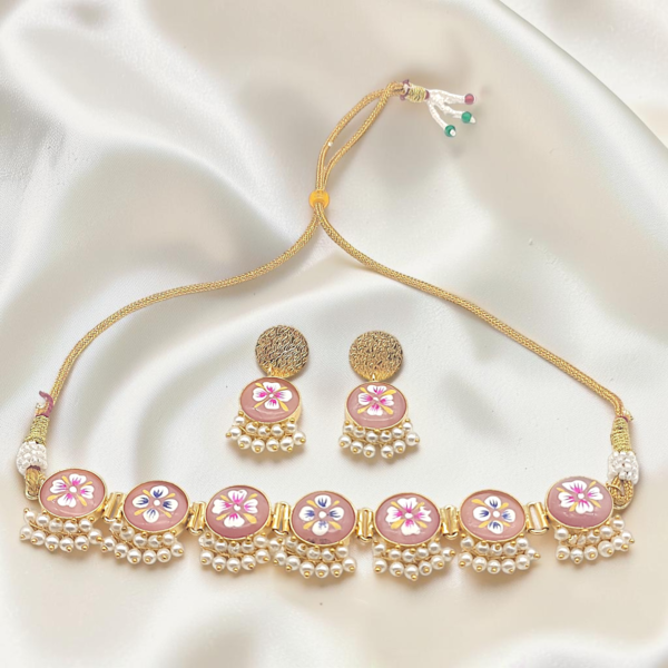 Pink Hand-Painted Brass Choker Set featuring Tanjore-inspired floral artwork, pearl accents, gold-tone brass finish and matching stud earrings.